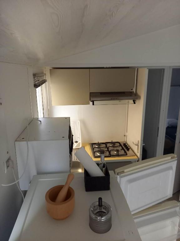 a small kitchen with a stove and a counter top at Mobilhome 6 pers avec Clim in Saint-Georges-de-Didonne