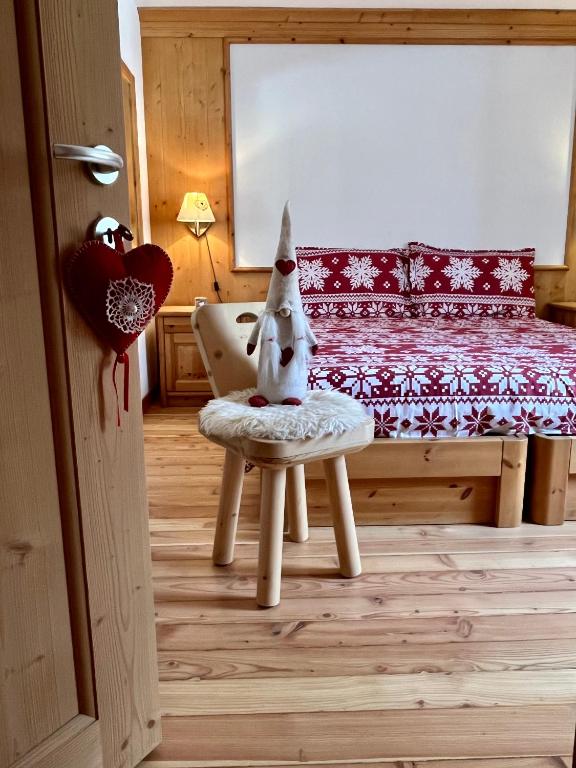 a bedroom with a bed and a chair with a dog on it at Haus Gobbis Transformational Retreat in the Dolomites in Gosaldo