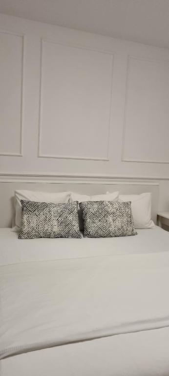 Una cama blanca con tres almohadas encima. en Modern apartment in the heart of Njivice, en Njivice