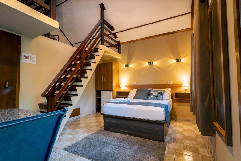 - une chambre avec un lit et un escalier dans l'établissement Pousada Villa Pinhal, à Santo Antônio do Pinhal