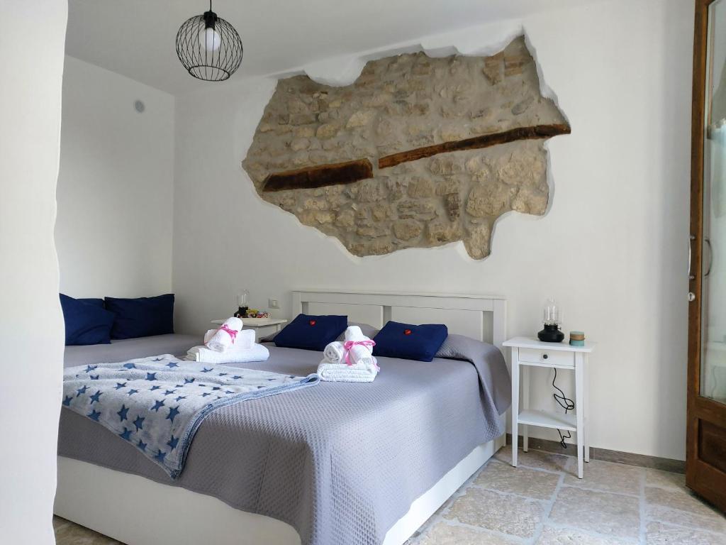een slaapkamer met een bed en een stenen muur bij B&B TraMonti in Cusano Mutri