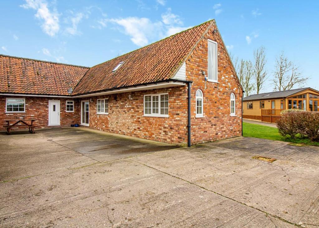 a brick house with a large driveway in front of it at Camper Uk Leisure Park in Doddington