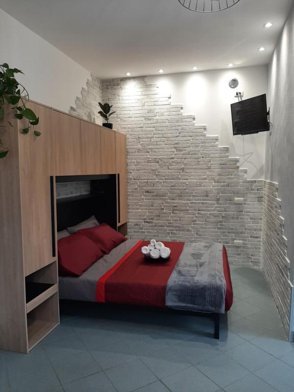 a bedroom with a bed and a brick wall at Vinessa Home in Peschiera del Garda