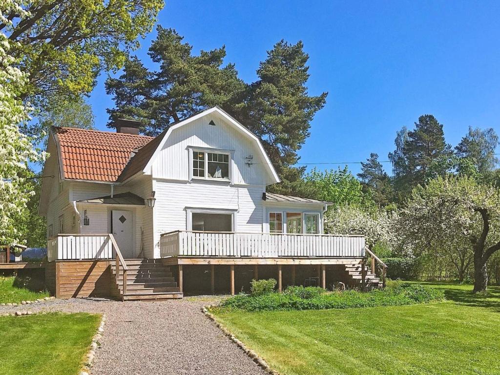 uma casa branca com um alpendre e um quintal em Holiday home ÅKERSBERGA V em Akersberga