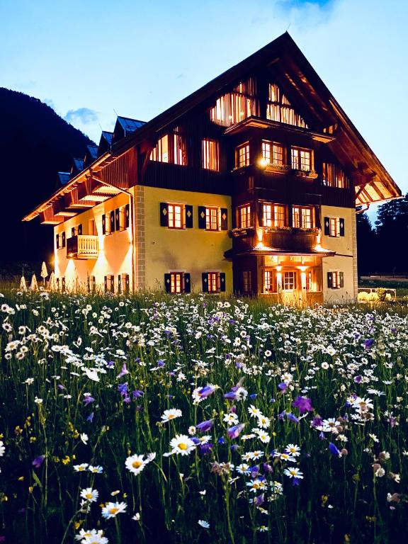 a field of flowers in front of a house at Natura Boutique Chalet Wellness SPA in Dobbiaco