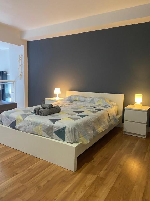 una camera da letto con un grande letto con due lampade sopra di Apartamentos Marquesado a Madrid