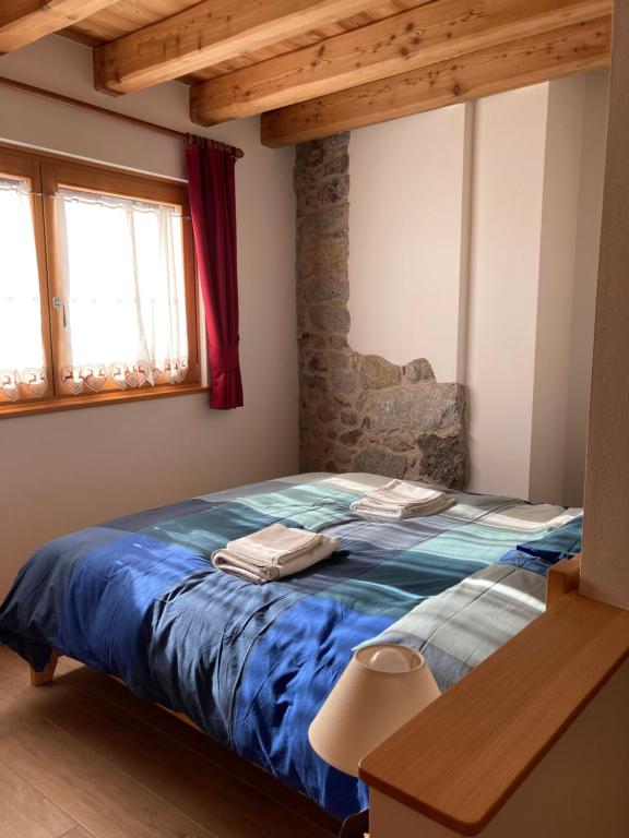 a bedroom with a bed with a blue comforter at IL moleta Affittacamere in Balbido-rango