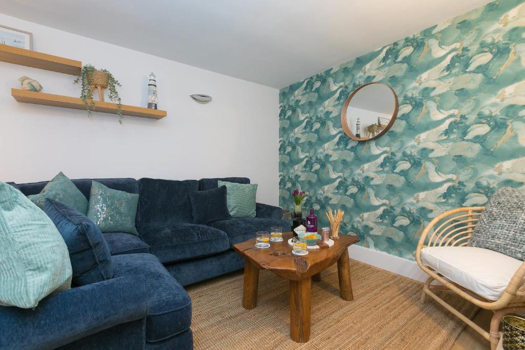 a living room with a blue couch and a table at Dream Achieved in St Ives