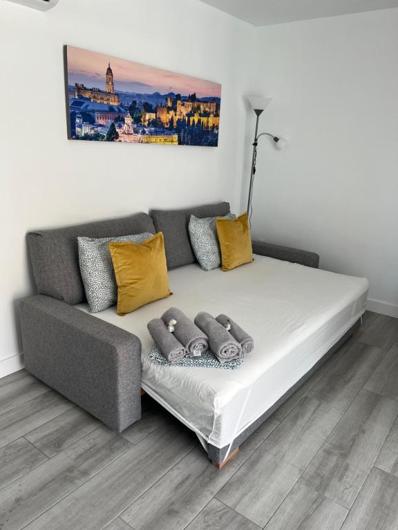 a couch in a living room with yellow pillows at Apartamento Fuengirola Puerto in Fuengirola