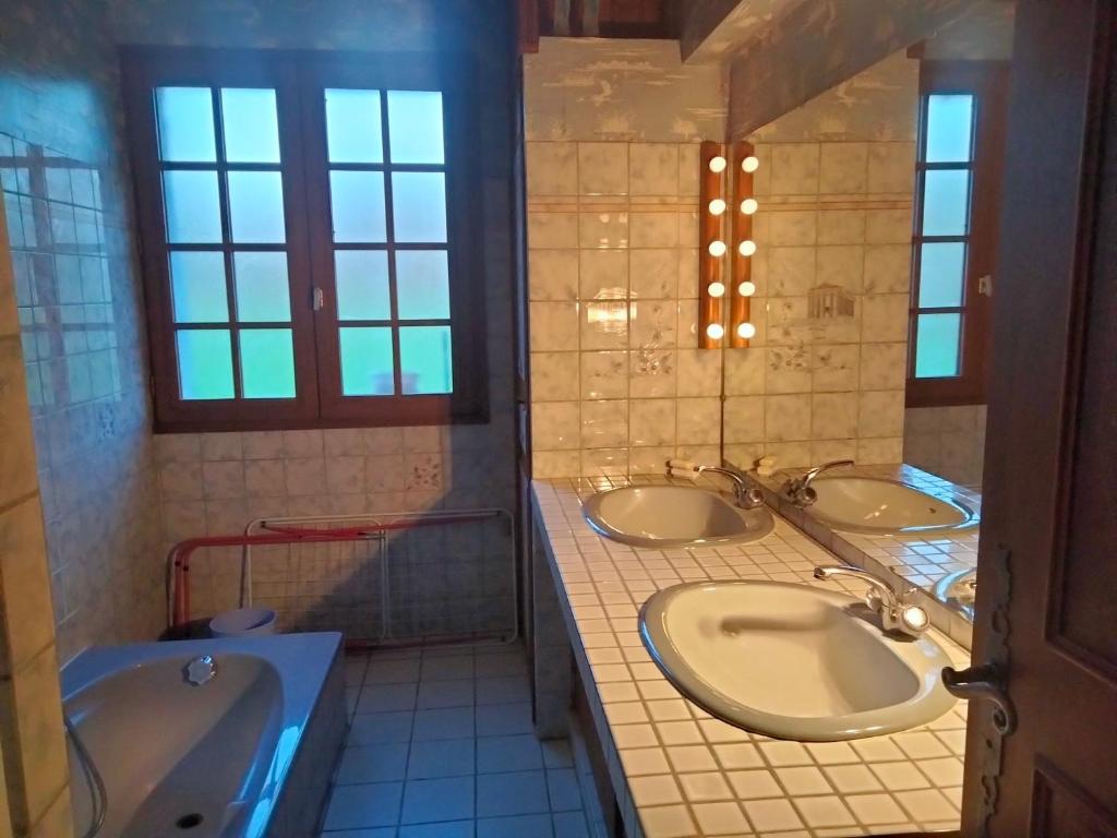 een badkamer met 3 wastafels en een bad bij Corneguerre Grand Brassac in La Peyzie