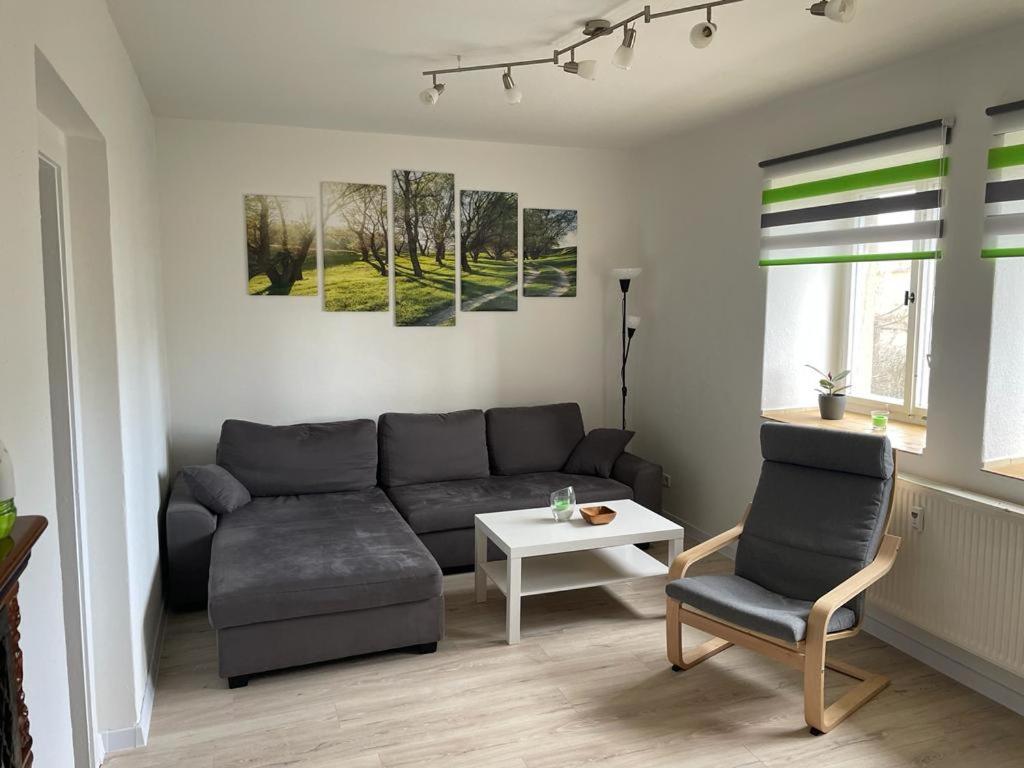 uma sala de estar com um sofá e uma mesa em Monteur Ferienwohnung OT Kleinwaltersdorf mit Außensitzecke und Grill em Freiberg
