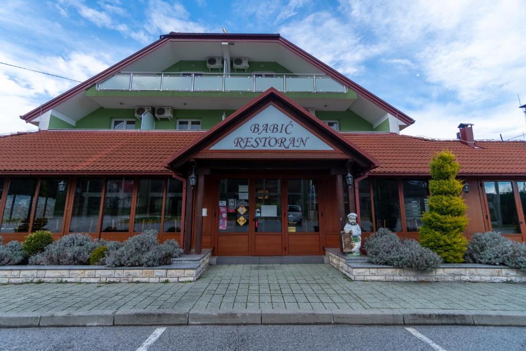 Vranovača的住宿－Hotel & Restaurant Babic，前面有标志的建筑