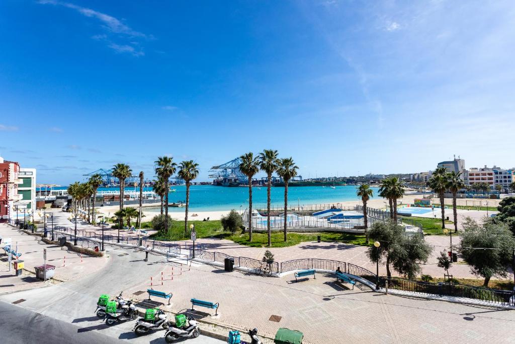vistas a una playa con palmeras y al océano en Gospa 58 - 2 bedroom apt en Birżebbuġa