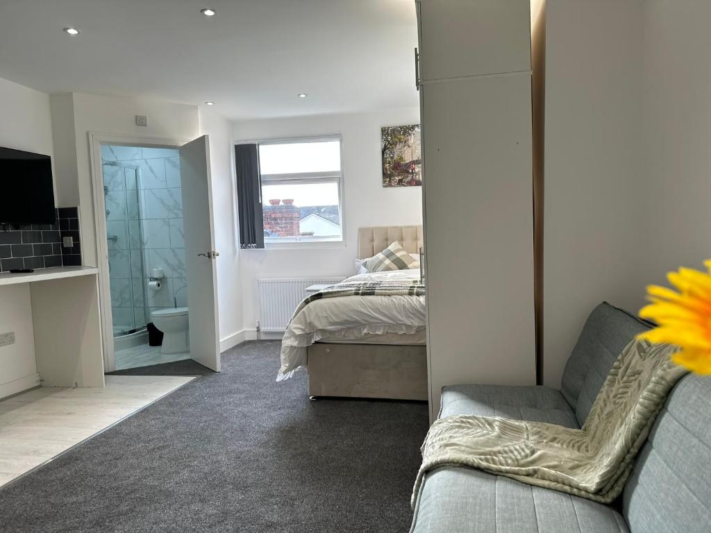 1 dormitorio con cama, sofá y TV en Regent Luxury Studio en Coventry