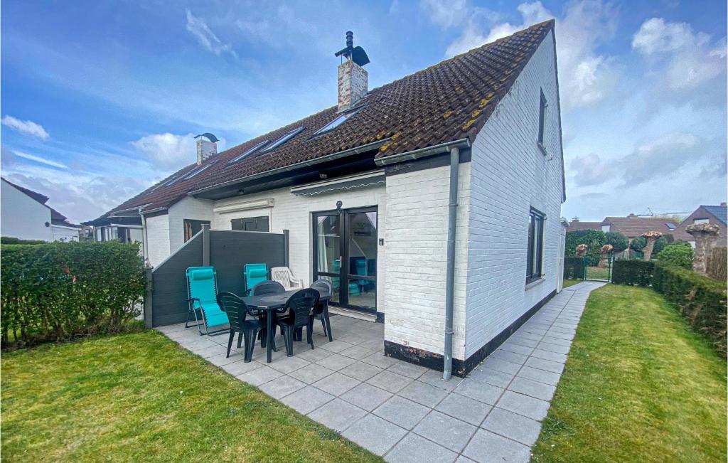 a small white house with a table and chairs at Gorgeous Home In Westende With Kitchen in Middelkerke