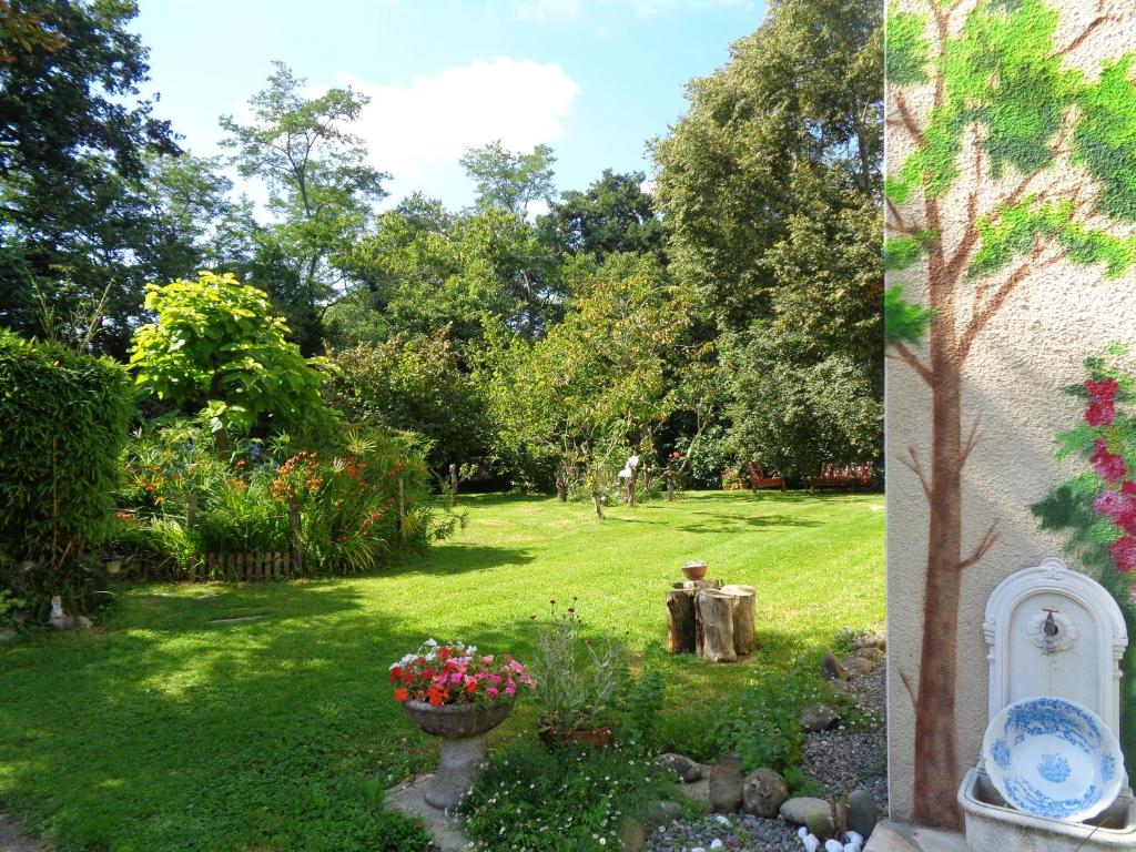 a yard with a garden with flowers in the grass at Maison d'Hôtes Béarnaise "Léchémia" in Salies-de-Béarn