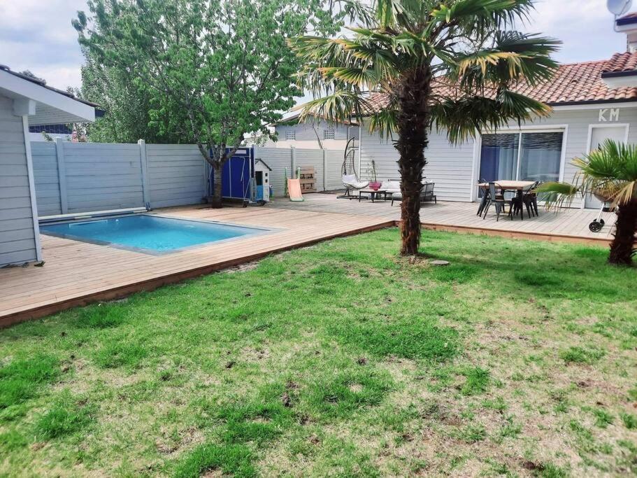 une arrière-cour avec une terrasse et une piscine dans l'établissement Maison entre Océan - Bassin d'arcachon, à Le Porge