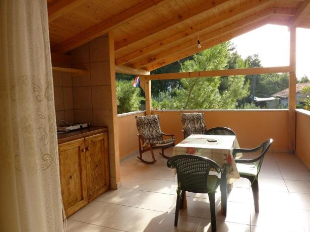 a porch with a table and chairs and a window at Studio Orange in Zavala