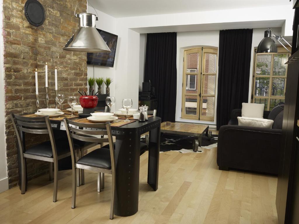 魁北克市的住宿－Les Immeubles Charlevoix - Le 1168，一间用餐室,配有黑色的桌子和椅子