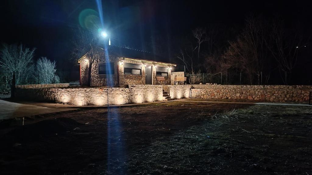 a house with a street light in front of a stone wall at Stone House Montenegro in Danilovgrad
