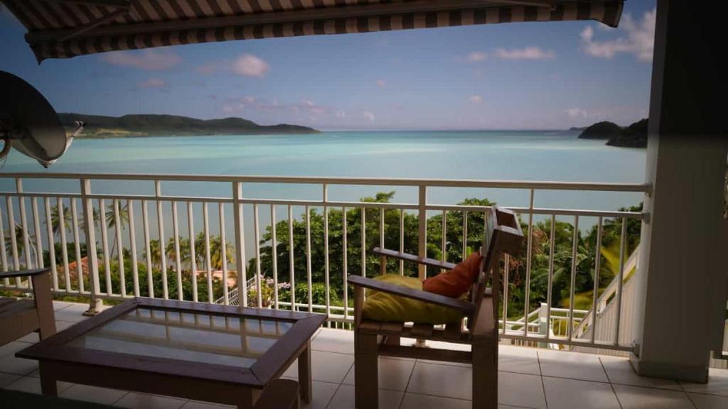 a room with a balcony with a view of the ocean at Résidence Belle Anse, F3 sans vis à vis, vue mer in La Trinité