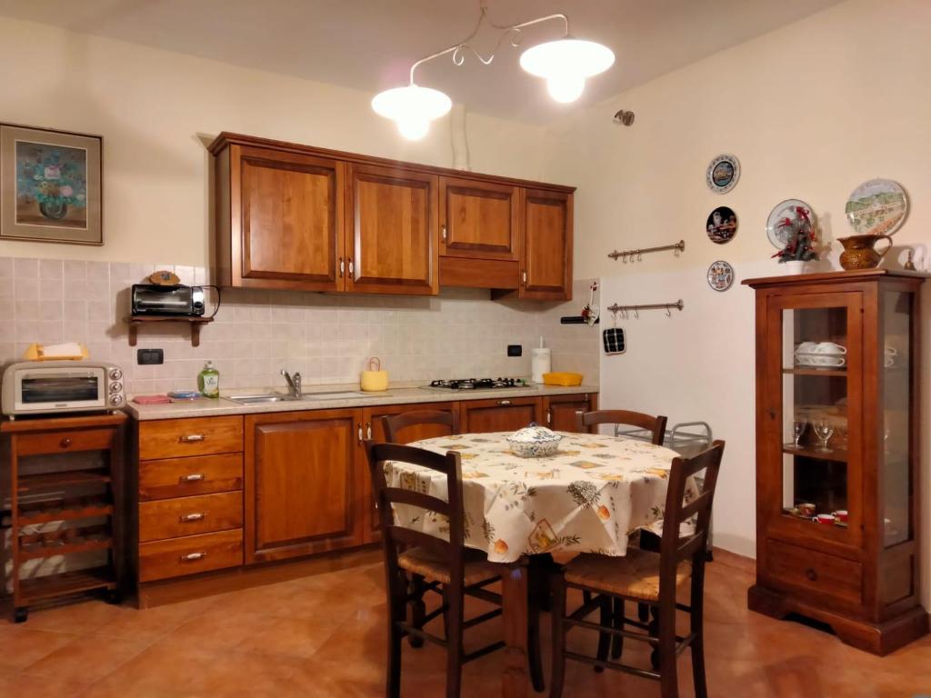 cocina con mesa con sillas y fregadero en Solerio 4 en Montescudaio