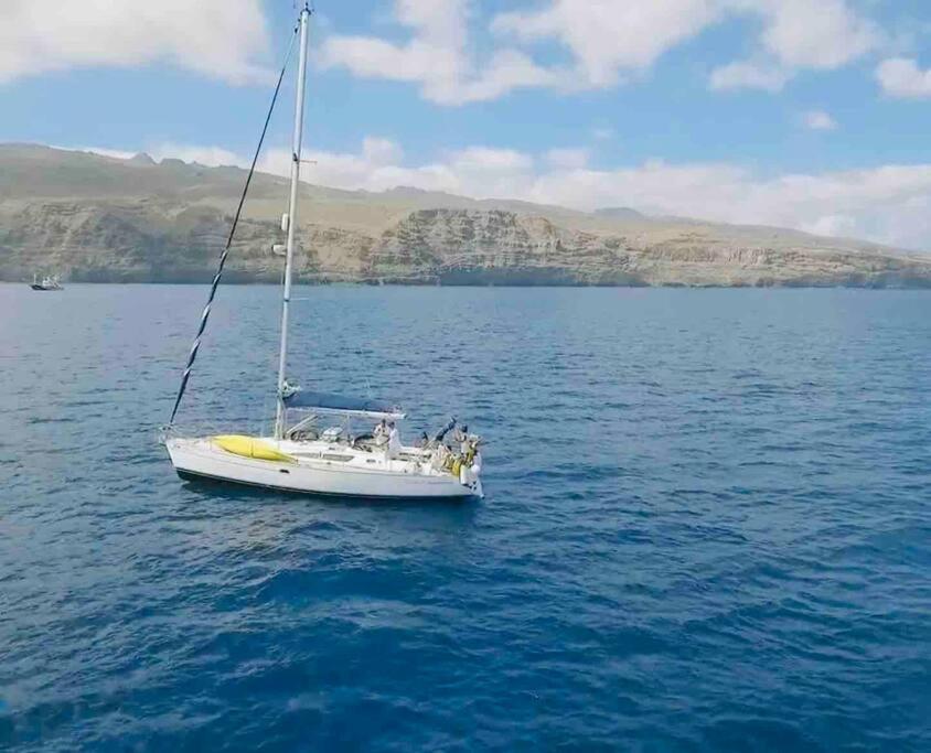 un bote blanco en medio de un cuerpo de agua en Brego, Velero para alojamiento, en Santa Cruz de Tenerife