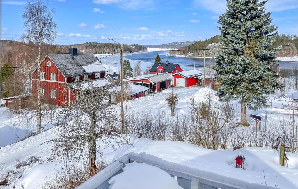 a red house in the snow next to a river at 3 Bedroom Nice Home In Lunde in Lunde