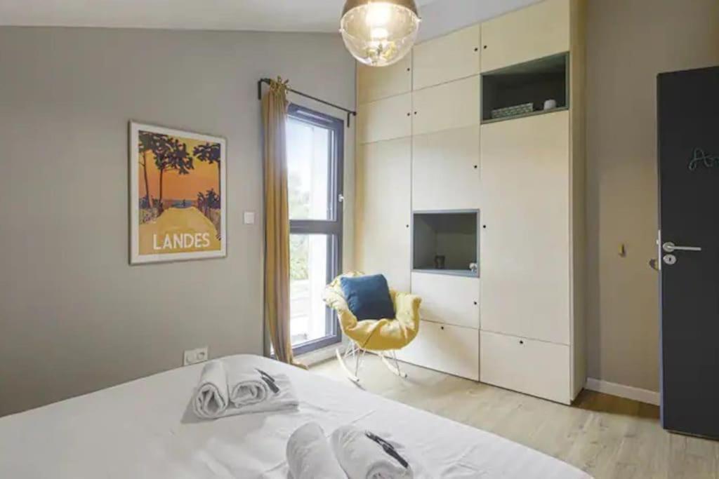 sypialnia z łóżkiem i żółtym krzesłem w obiekcie Superbe villa 5* avec piscine chauffée w mieście Labenne