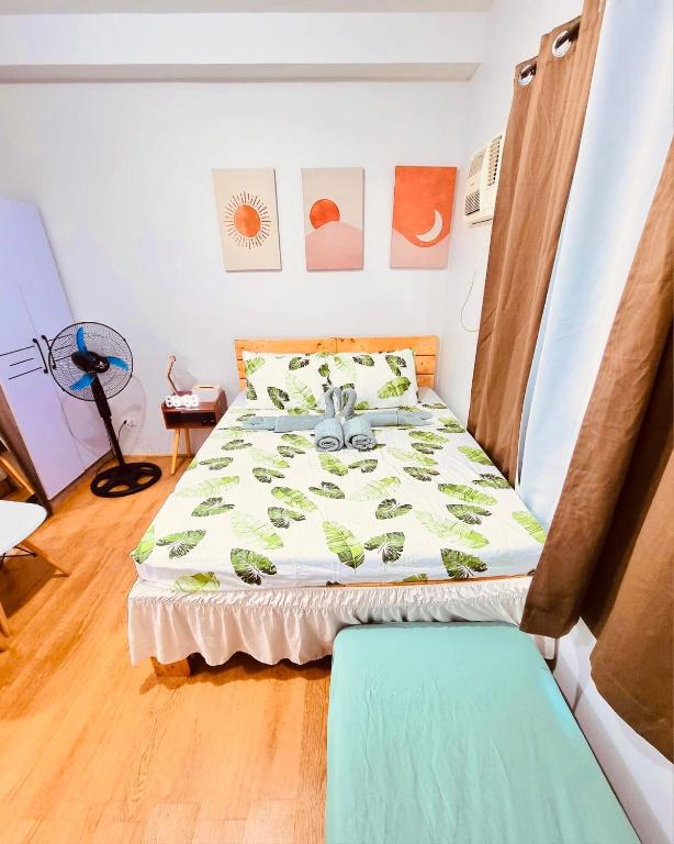 a bedroom with a bed with a green comforter at Mesatierra Garden Residences in Davao City