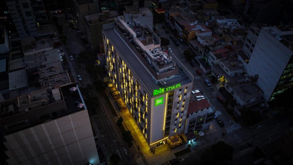 una vista sul soffitto di un edificio con un cartello verde sopra di ibis styles Lima San Isidro a Lima