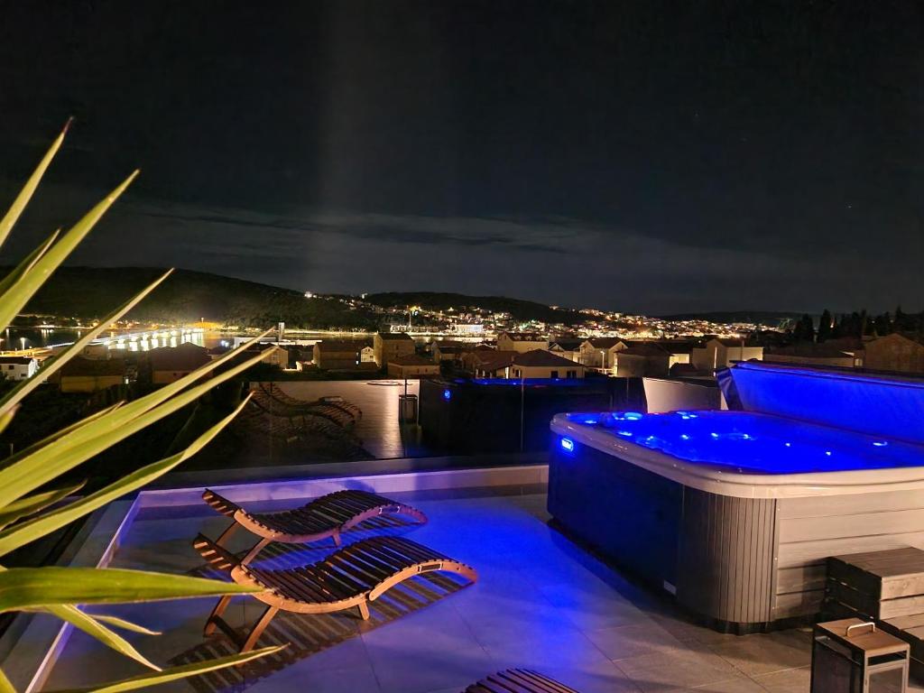 - un balcon avec 2 chaises et un bain à remous la nuit dans l'établissement Penthouse Apartman Marčelina in Trogir, à Trogir