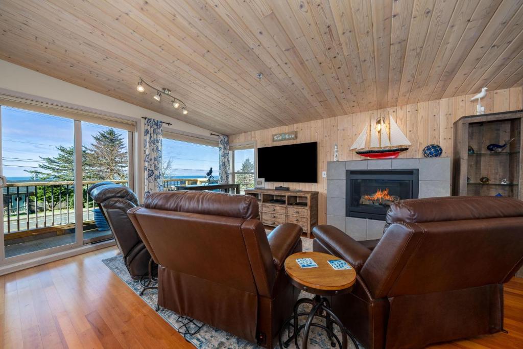 a living room with leather furniture and a fireplace at Tranquility Cove in Depoe Bay