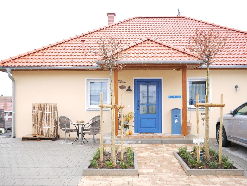 una casa con una puerta azul y una mesa en Wolke 7, en Görwihl