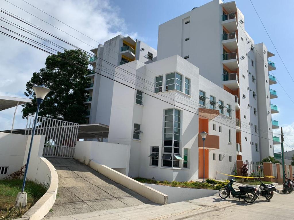 a white building with two motorcycles parked in front of it at CIC APARTAMENTOS cerca UNICOR IMAT in Montería