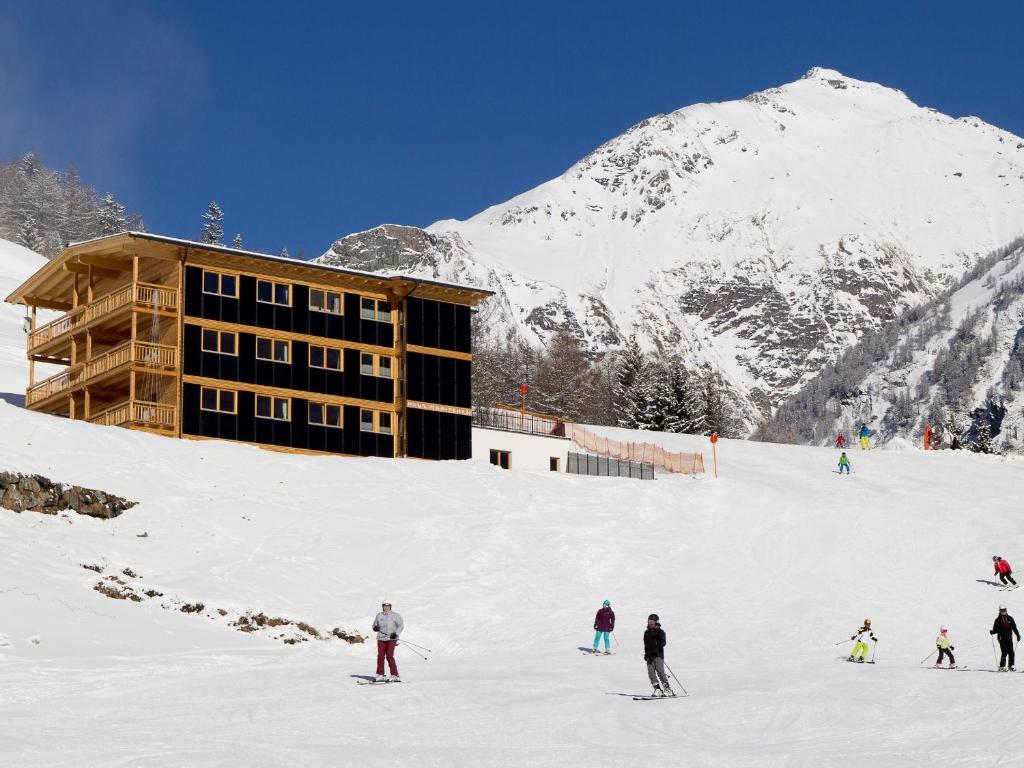 eine Gruppe von Menschen, die einen schneebedeckten Berg hinunterfahren in der Unterkunft Haus Maritchen in Kals am Großglockner