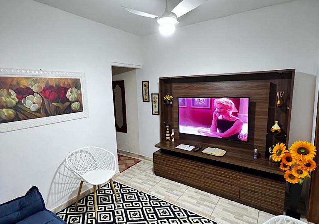 sala de estar con TV de pantalla plana en la pared en Cantinho de Maria, en Aparecida