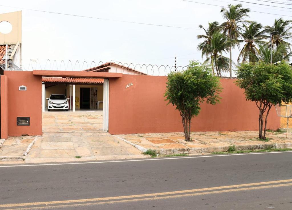 a orange building with a car in a garage at Casa de Luís Correia in Luis Correia