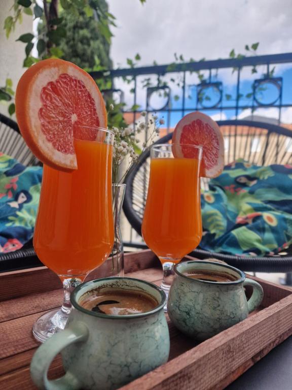 uma bandeja com dois copos de sumo de laranja e duas chávenas em Kathisma Trebinje em Trebinje