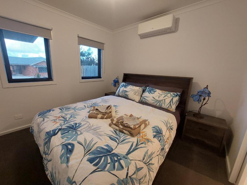 a bedroom with a bed with a blue and white blanket at bamboo in Apollo Bay