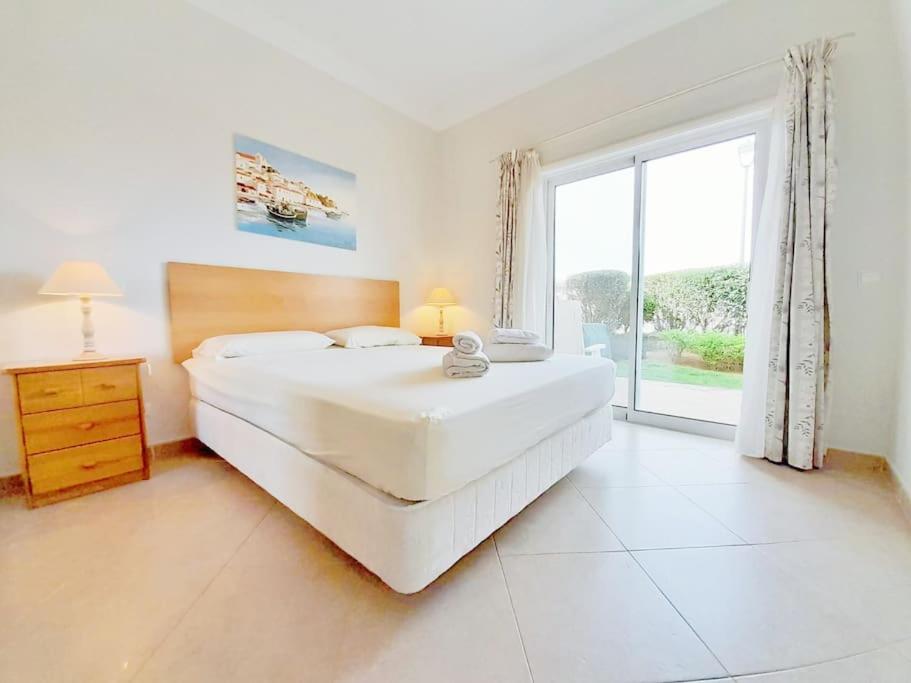 a large white bedroom with a large bed and a window at Algarver II-Boavista Golf Fairview Swimpool Apartment in Lagos