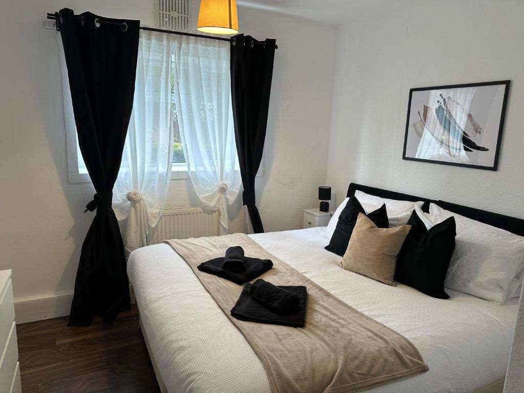 - une chambre avec un lit doté de deux chapeaux noirs dans l'établissement Lovely 2Bedroom 4mins from Wimbledon station, à Londres