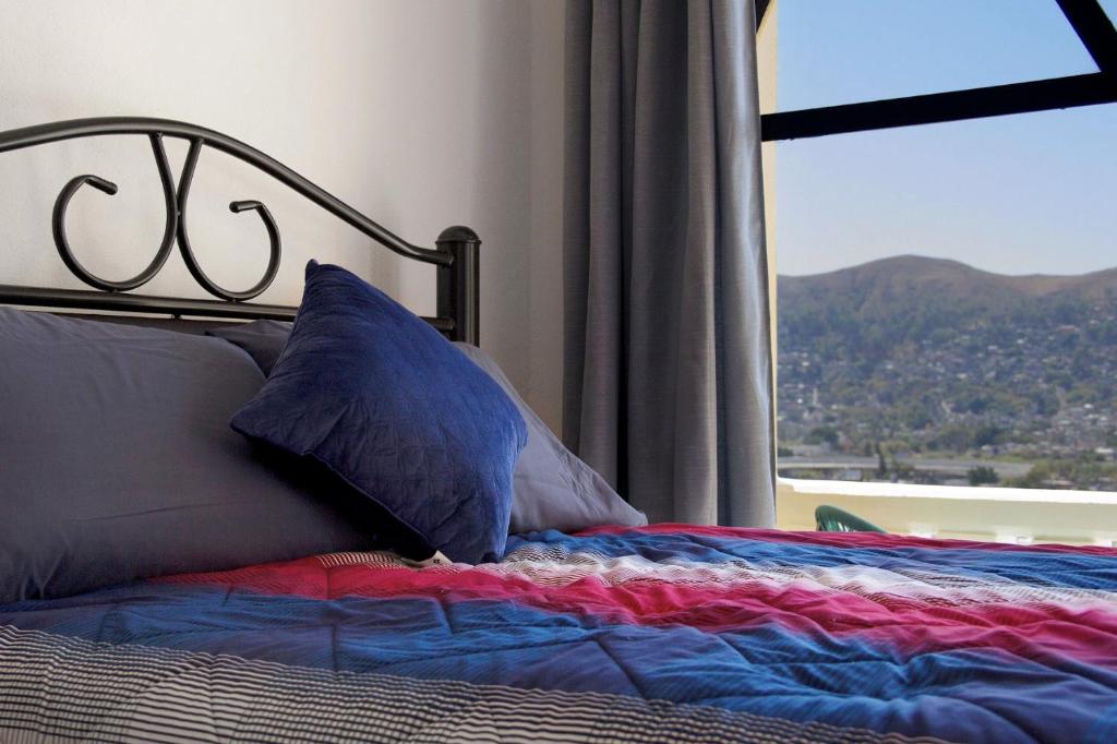 a bed with pillows and a window with a view at Casa Santiago in Oaxaca City