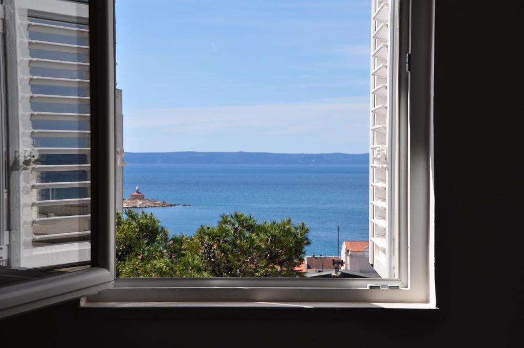 an open window with a view of the ocean at Apartment Sea San in Makarska