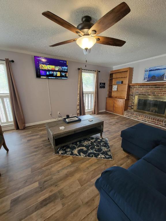 a living room with a ceiling fan and a fireplace at Convenient and Comfortable in Macon