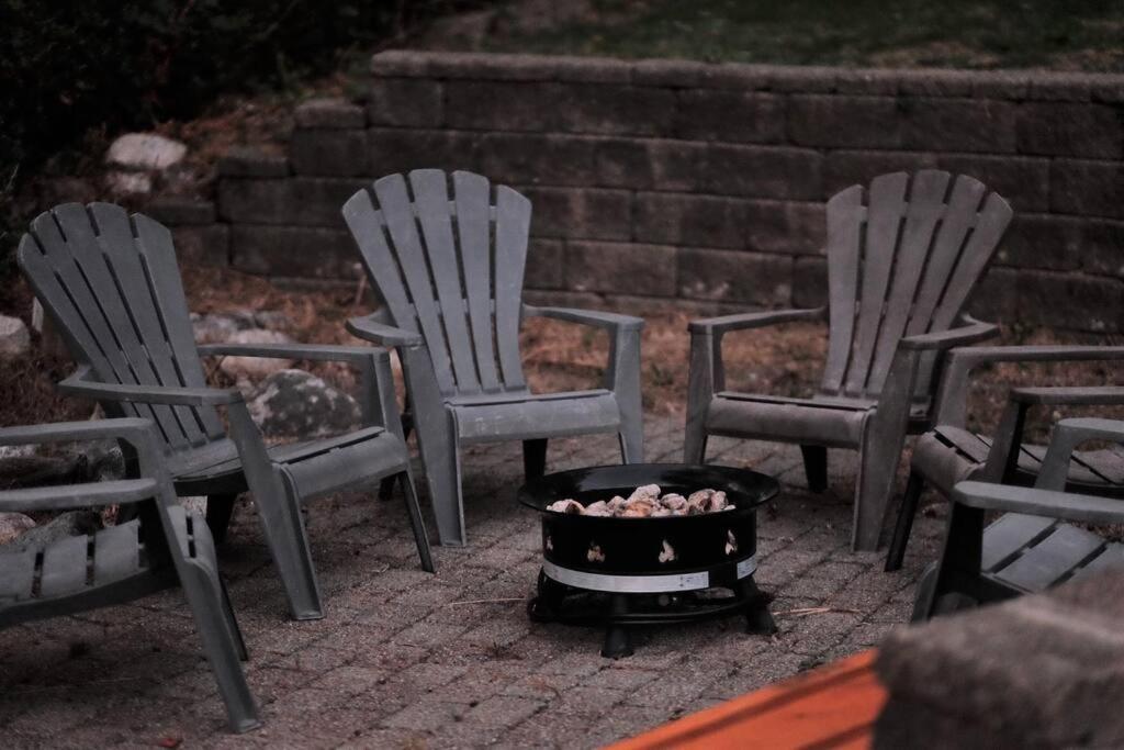 three chairs and a fire pit on a patio at Tranquil And Spacious suite in Anmore in Ioco