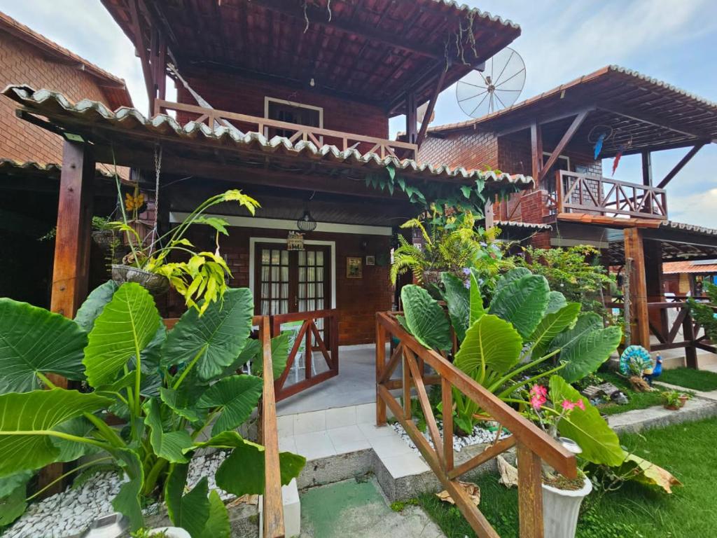uma casa com um jardim em frente em Lindo chalé completo para até 10 pessoas com piscina aquecida em Gravatá