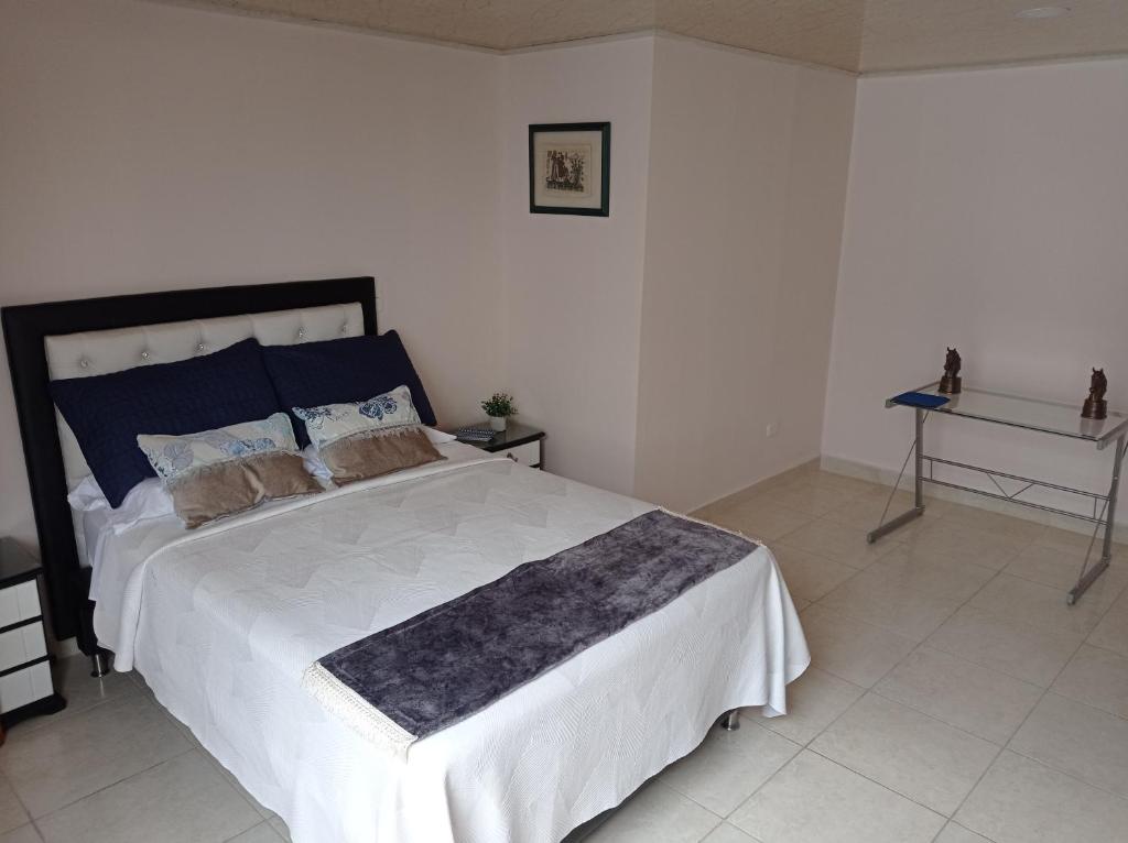 1 dormitorio con 1 cama grande y 1 mesa en Apartamento ideal si buscas ubicación y espacio, en Pereira