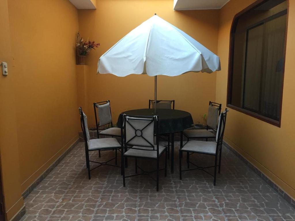 una mesa con sillas y una sombrilla en una habitación en Los Girasoles, en La Molina
