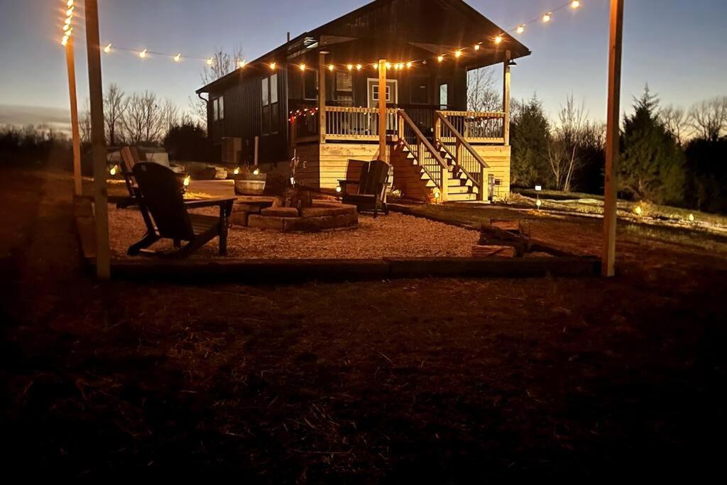 een huis met een veranda met verlichting bij Bourbon Barrel Cottages #1 of 5 on Kentucky trail in Lawrenceburg